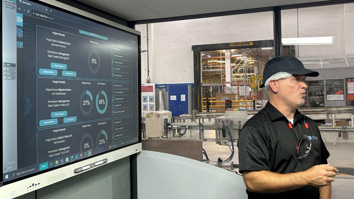 Professional using a SMART interactive display to streamline factory processes under lean management principles.